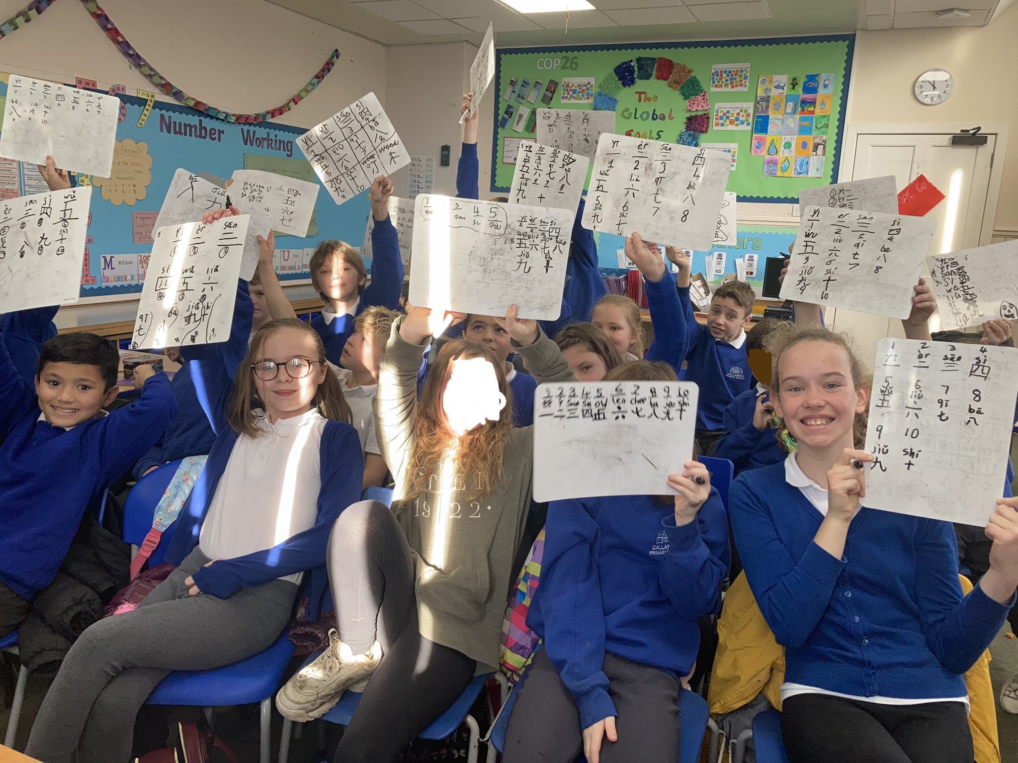 photo of pupils participating in the programme holding up their work